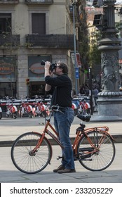 Barcelona, Spain - October 29, 2014: Cyclist standing on a walk taking a photograph