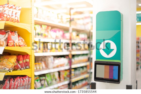The barcode price scanner\
on the wall in a supermarket for self service check price and\
information, The new technology for independently checks the value\
of the goods.