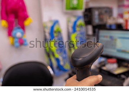 Barcode scanner with cashier screen in the background