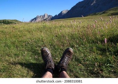 Bare calves and walking shoes suggest a hiker resting on the grass in July (Col des Champs, Parc du Mercantour, Alpes-de-Haute-Provence, France).