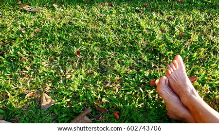 bare feet casting shadow on green grass