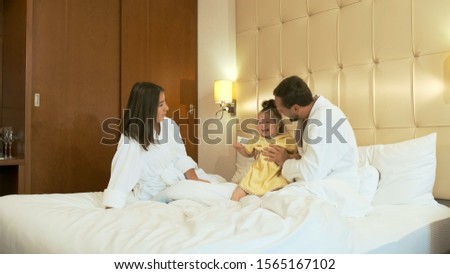 Similar – Relaxed mother and sons playing over the bed