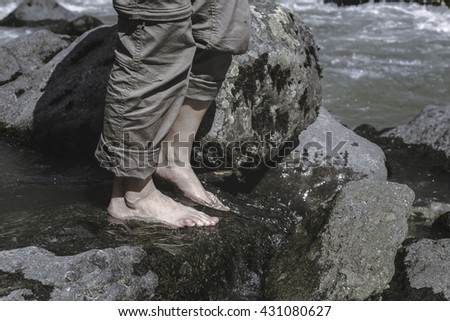 Bare feet girls walking in a stream of mountain river. Travel Lifestyle concept healthy lifestyle.