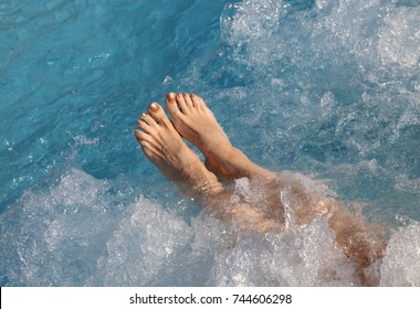 Bare Feet And Legs Of The Young Woman During Hydro Massage Therapy In The Spa Pool