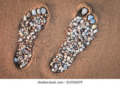 Bare feet made of pebble on the sandy beach - Shutterstock ID 313765079