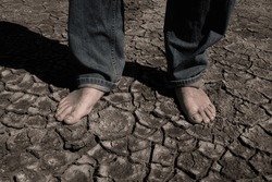Bare Feet Of A Man On A Dry Lake