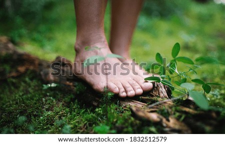 Bare feet of man standing barefoot outdoors in nature, grounding concept.