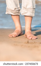 Bare Feet In The Men's Linen Trousers Near The Sea