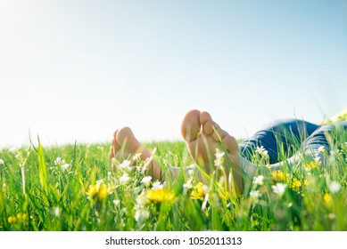 Bare Feet On Spring Grass And Flowers