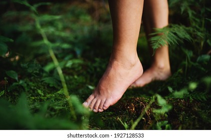 Bare feet of woman standing barefoot outdoors in nature, grounding concept.