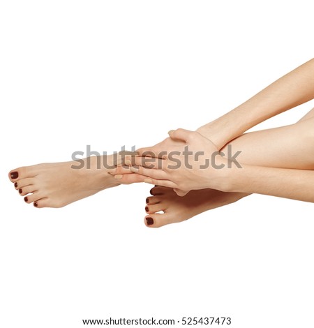 Bare female crossed legs and hands, top view.