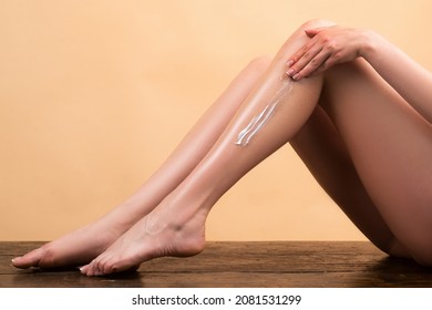 Bare foot leg of woman. Female hands applying cream on the skin, close up. Cosmetic cream on woman leg with clean soft skin. Applying moisturizer cream on legs. Cellulite or anti cellulite treatment.