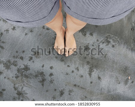 Bare Foot on a beach, grey sand 