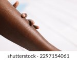 Bare legs of African woman closeup, blurred background free copy space. Black person lying with bent legs. Hairy and unshaven legs, new normal, beauty and fashion, body positive. 