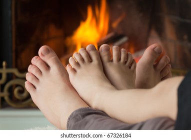 Bare legs a little girl and her sisters are heated by an open fire hearth