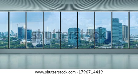 A bare office building interior. A modern panoramic window and view of Alabang skyline. Interior concept. Architectural background.