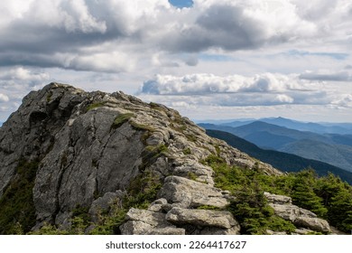 Bare rock and distant mountains on Vermont hill top with dramatic clouds. - Powered by Shutterstock