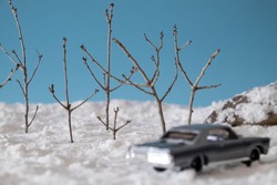 Bare Trees In An Artificially Created Snowy Landscape In The Studio, Clear Sky, Blurry Toy Cars In The Foreground.