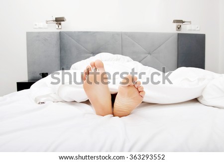 Bare woman's feet in bedroom.