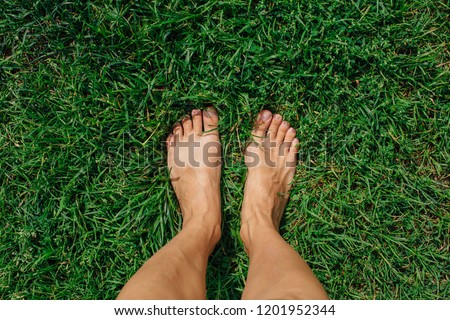 Bare woman's feet on the green grass