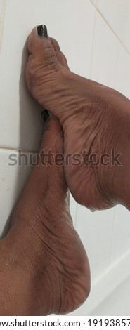 Bare wrinkled ebony feet with painted toe nails