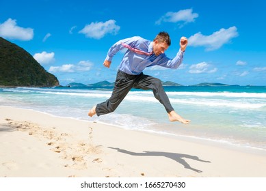 Barefoot Businessman Jumping Across An Empty Tropical Beach