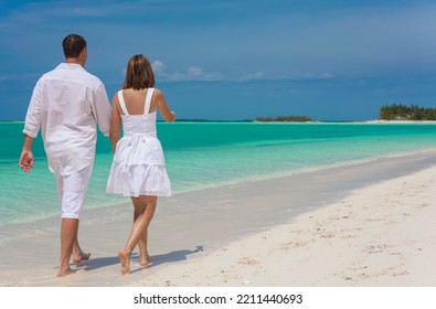 Barefoot Caucasian Couple In White Clothes Carefree Outdoors By The Ocean On Tropical Luxury Caribbean Travel Resort 