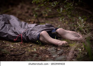 Barefoot Dead Body In The Woods. Murder Victim Lying On The Ground In The Forest