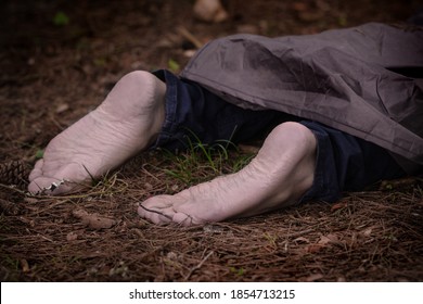 Barefoot Dead Body In The Woods. Murder Victim Lying On The Ground In The Forest. Murdered Citizen, Crime Scene