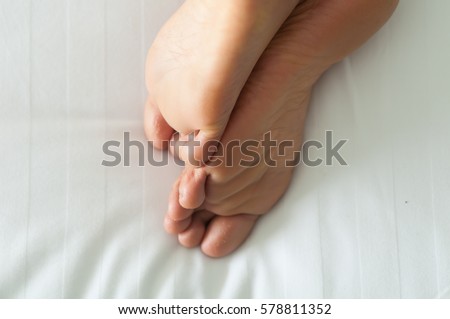 barefoot female feet on bed