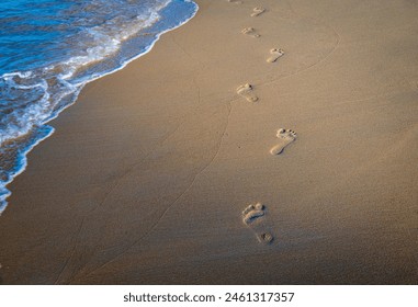 Barefoot footprint trail and gentle waves on sandy beach graphic resource background  - Powered by Shutterstock