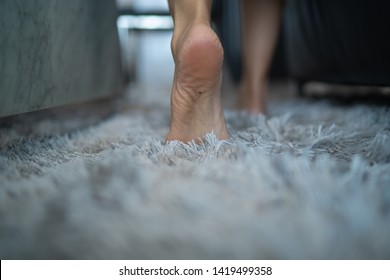 barefoot girl walking on carpet in living room her
