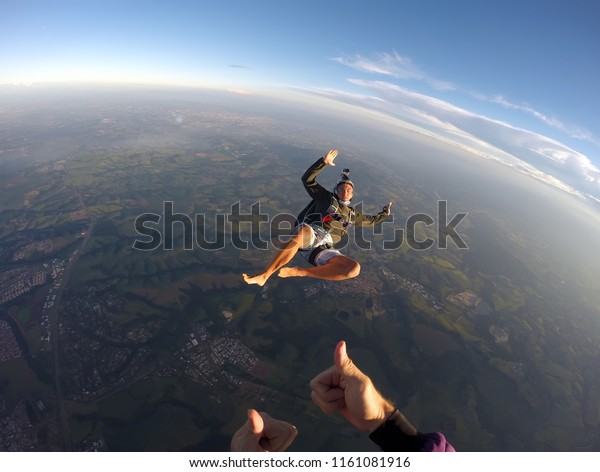 Barefoot man\
jumping from parachute at\
sunset.