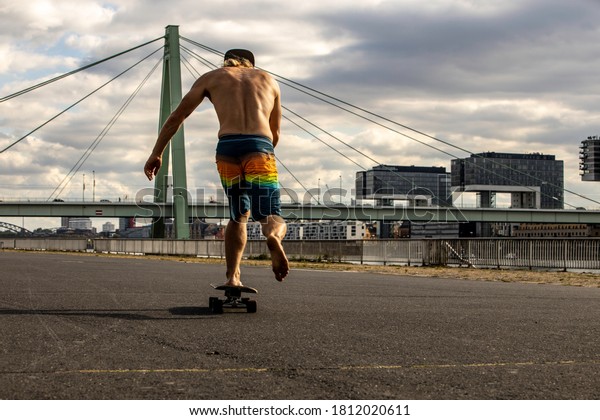 barefoot man\
skateboarding on the\
street