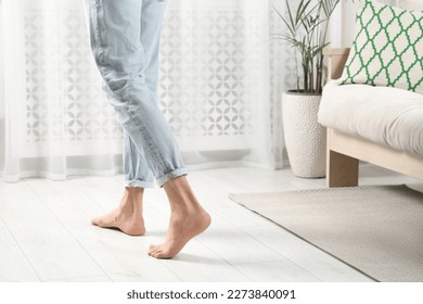 Barefoot man walking on white parquet at home, closeup. Heated floor - Powered by Shutterstock