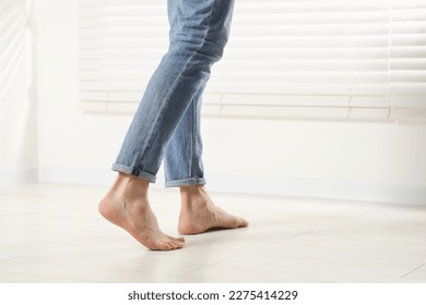 Barefoot man walking on white parquet indoors, closeup. Heated floor - Powered by Shutterstock