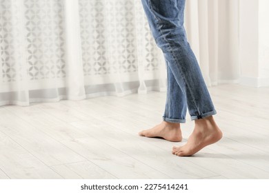 Barefoot man walking on white parquet indoors, closeup. Heated floor - Shutterstock ID 2275414241