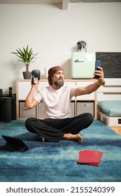 Barefoot Mature Male With Beard Smiling And Taking Selfie While Sitting On Floor During Break In Fitness Workout At Home