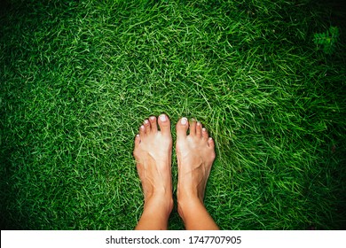 Barefoot on a green grass.