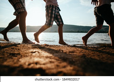 barefoot running on the beach, family running bare feet on the beach, silhouettes of feet, group of people on the sandy beach in summer