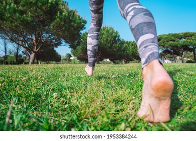 Barefoot Walking. Sporty Barefoot Woman Walking On The Green Grass. Young Female Legs Running Barefoot
