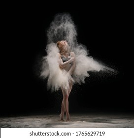 Barefoot woman dancing in cloud of sand