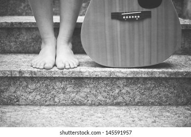 A Barefoot Woman With A Guitar