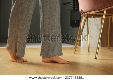 Barefoot woman on the wooden floor. Concept of the underfloor heating in the apartment.	