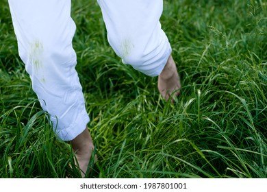 Barefoot Woman Running On The Grass In White Pants. Daily Life Dirty Stain For Wash And Clean Concept. High Quality Photo