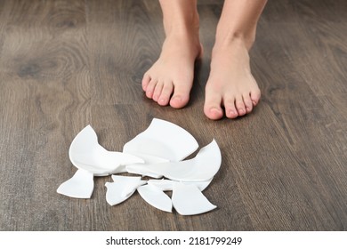 Barefoot Woman Standing Near Broken Plate On Floor, Closeup