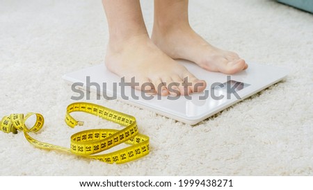 Barefoot woman standing on digital scales. Concept of dieting, loosing weight and healthy lifestyle.
