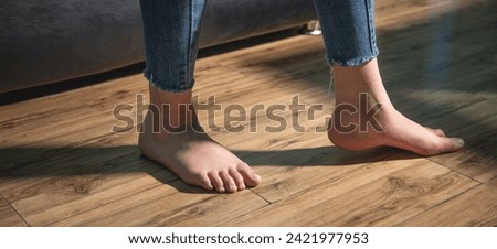 Barefoot woman walking on floor at home.