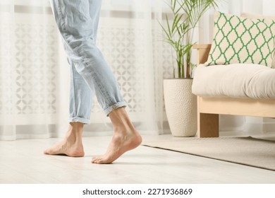 Barefoot woman walking on white parquet at home, closeup. Heated floor - Shutterstock ID 2271936869