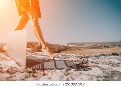 Barefoot Woman Walks Past Laptop on a Blanket on a Cliffside - Powered by Shutterstock